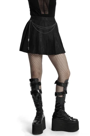 Black gothic pleated mini skirt with detachable waist chains and coffin pendant, front low-angle view on model