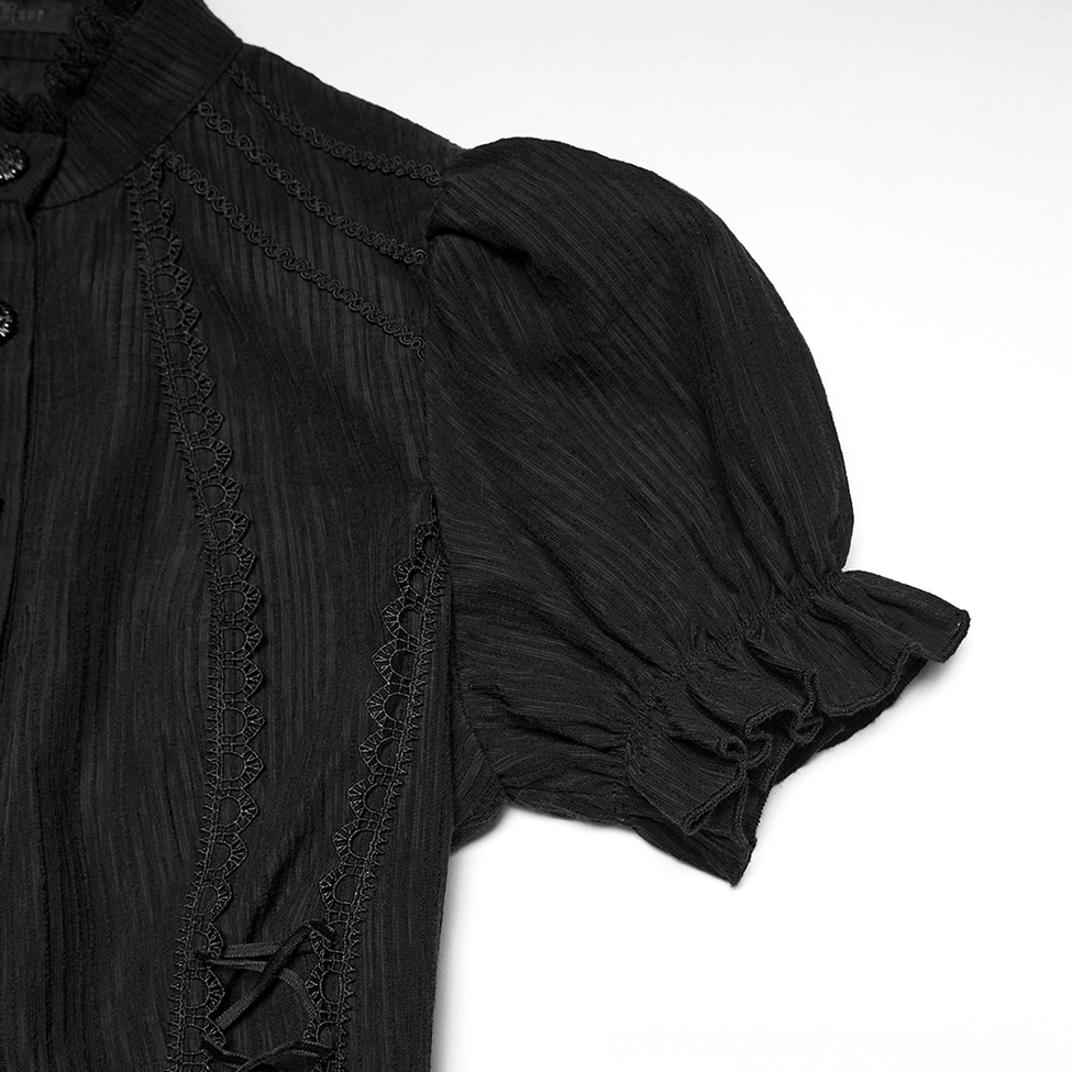 Close-up detail of black gothic blouse showing ruffled puff sleeve, lace seam trim and decorative button on cuff