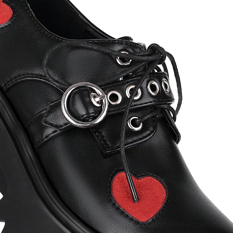 Detailed front view of gothic platform pump vamp showing black leather, red heart patch, and metal lace hardware