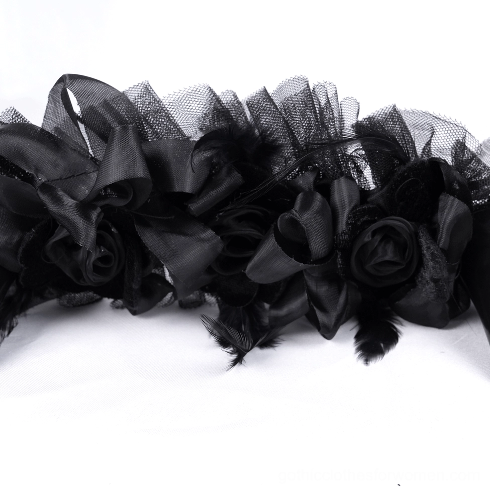 Close-up macro view of gothic headpiece base trim showing black satin roses, tulle mesh construction, and delicate feather trimmings