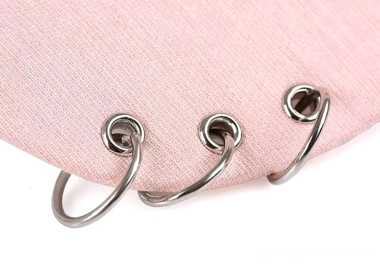 Three silver metal hoop rings on soft cotton brim of gothic baseball cap close-up