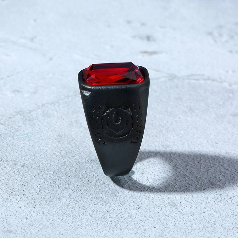Black red-gem gothic ring front view clear embossed logo on ring shoulder concrete background
