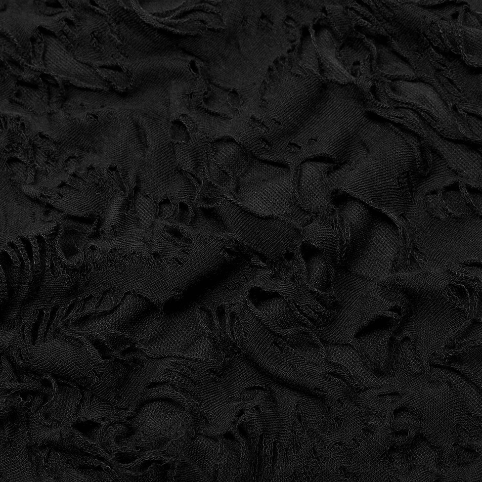 Close-up of black distressed ripped fabric surface showing shredded and frayed textile detail