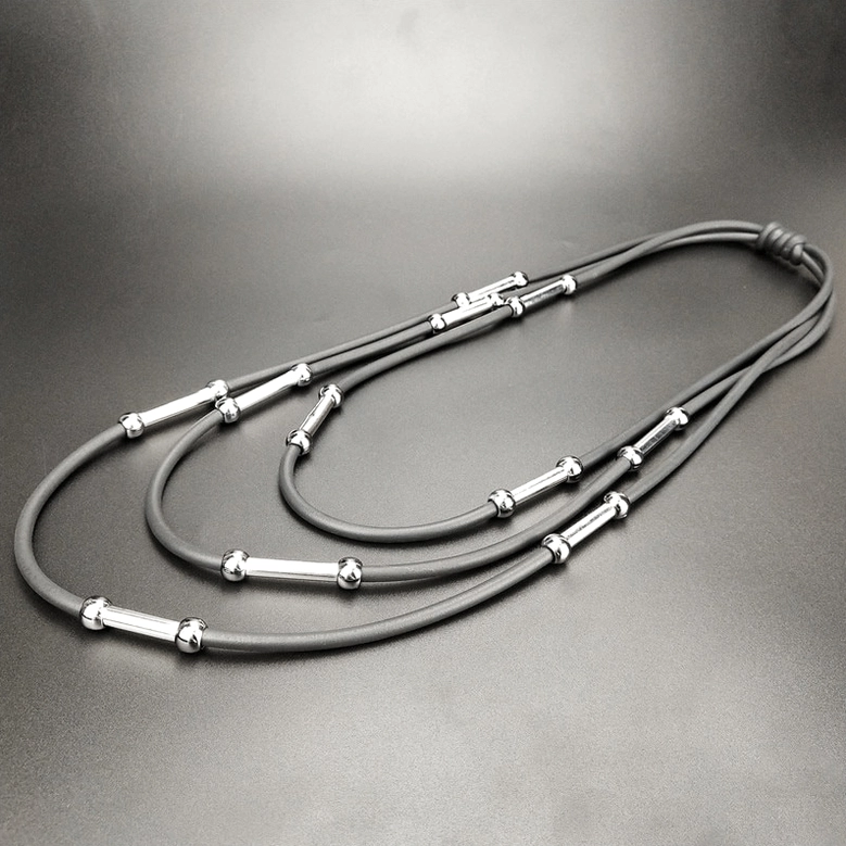 Multi-layer gray rubber rope gothic necklace overhead flat lay on dark background