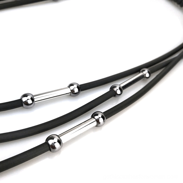 Macro side view of black rubber rope strands with silver hardware on gothic necklace