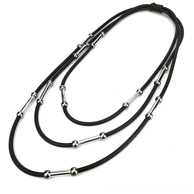 Handmade black rubber rope necklace overhead flat lay showing elastic knot closure and metal decorations