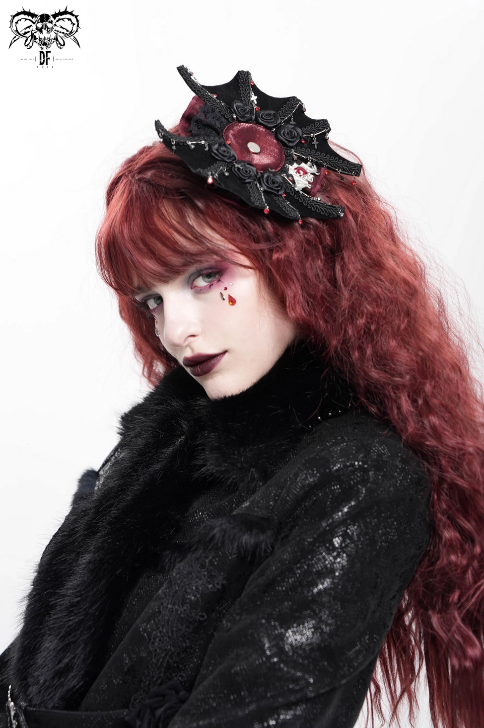 Close-up detail shot of gothic hair clip displaying cross embellishment, burgundy rose accents, and ornate metalwork against white background