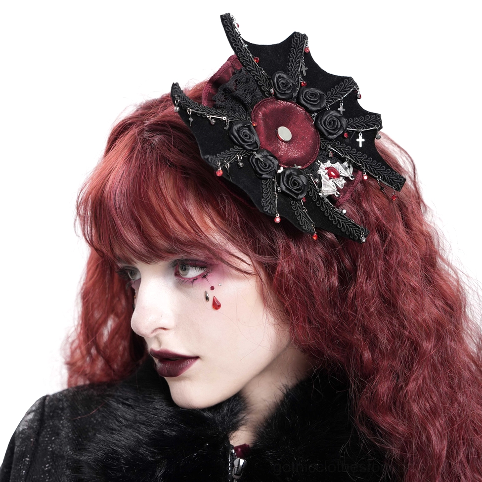 Right three-quarter portrait of model with curly red hair wearing black gothic rose cross hair clip with intricate spiderweb design