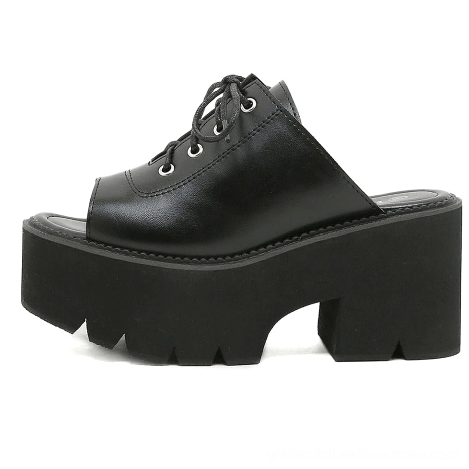 Full side profile of black mule sandal showing lugged thick sole and open heel slip-on design