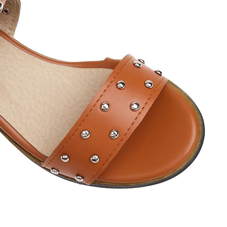Close-up detail of open toe strap with silver round rivets and brown faux leather construction