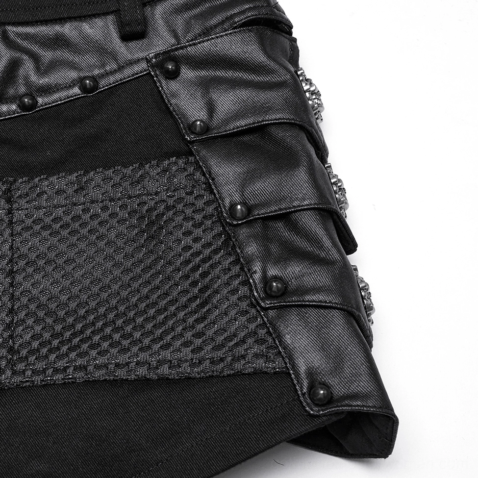 Detail shot highlighting the construction and craftsmanship of black studded gothic shorts with skull elements and rivet placement
