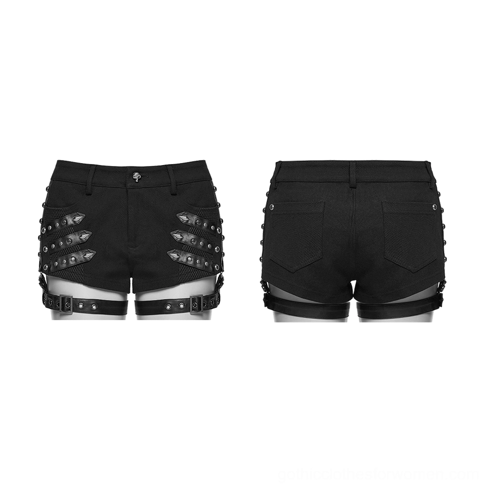 Flat lay comparison of black studded gothic shorts showing front and back with mesh panels, leg straps, and pocket detailing