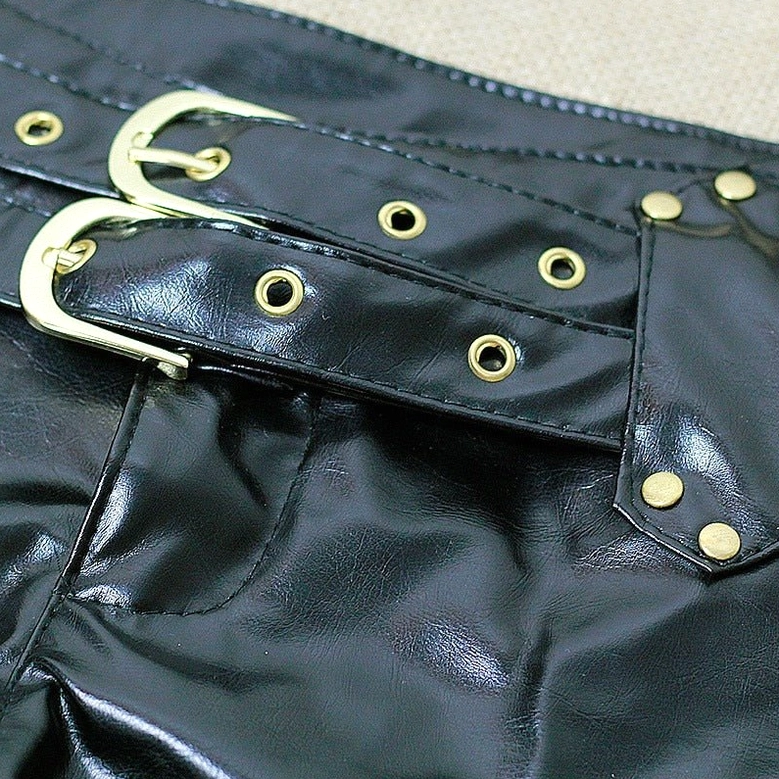 Macro detail of black leather shorts double gold buckles and rivet holes craftsmanship