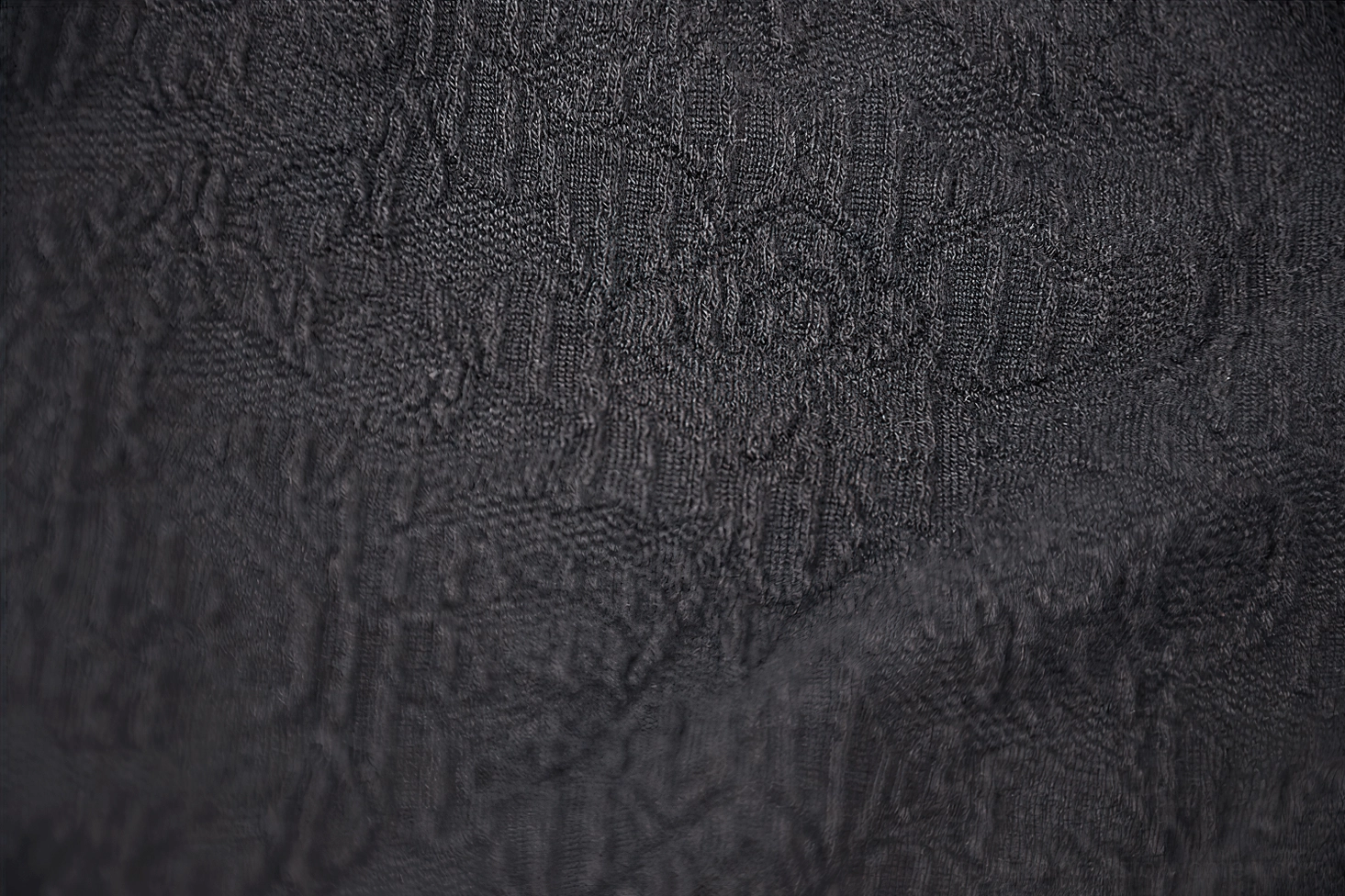 All-over subtle jacquard floral pattern in solid black woven fabric - texture and weave detail