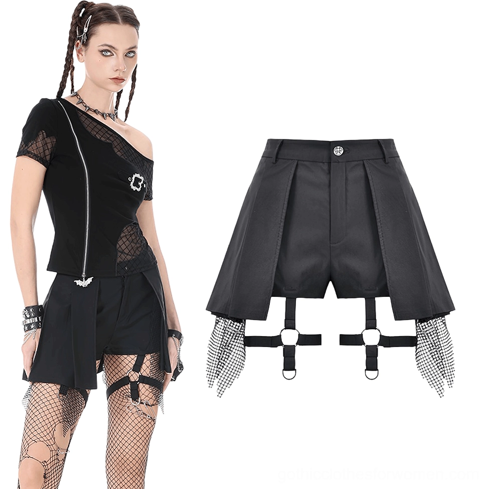 Full body styling of black gothic shorts worn with one-shoulder mesh top and fishnet stockings, front view