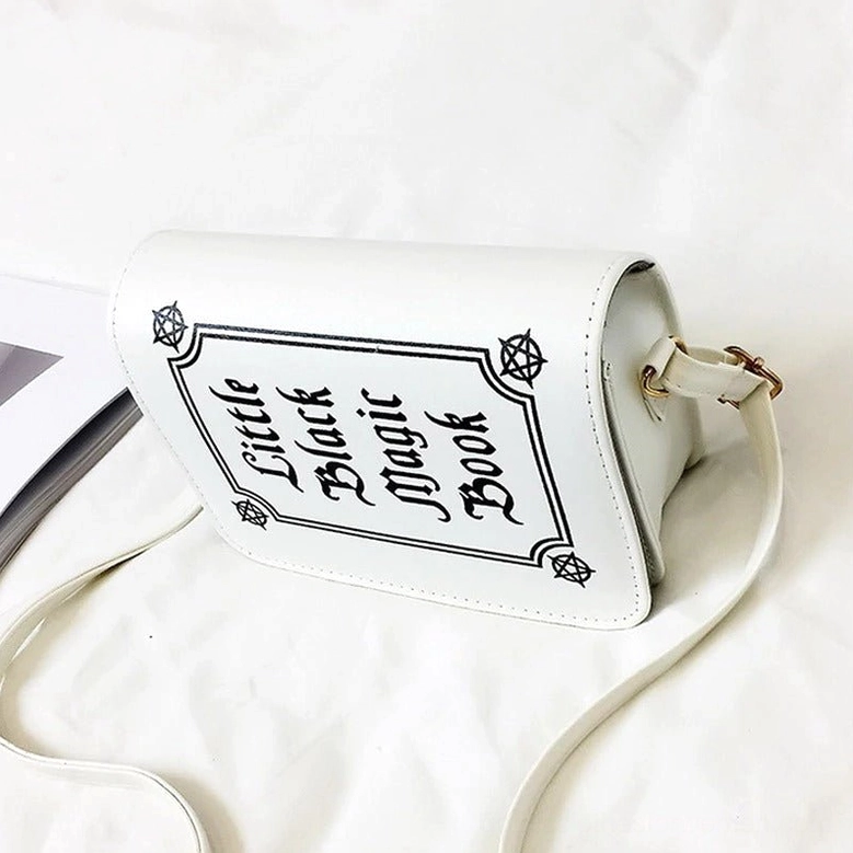 White gothic letter crossbody bag 3/4 view with magazine styling and reversed gothic text print detail