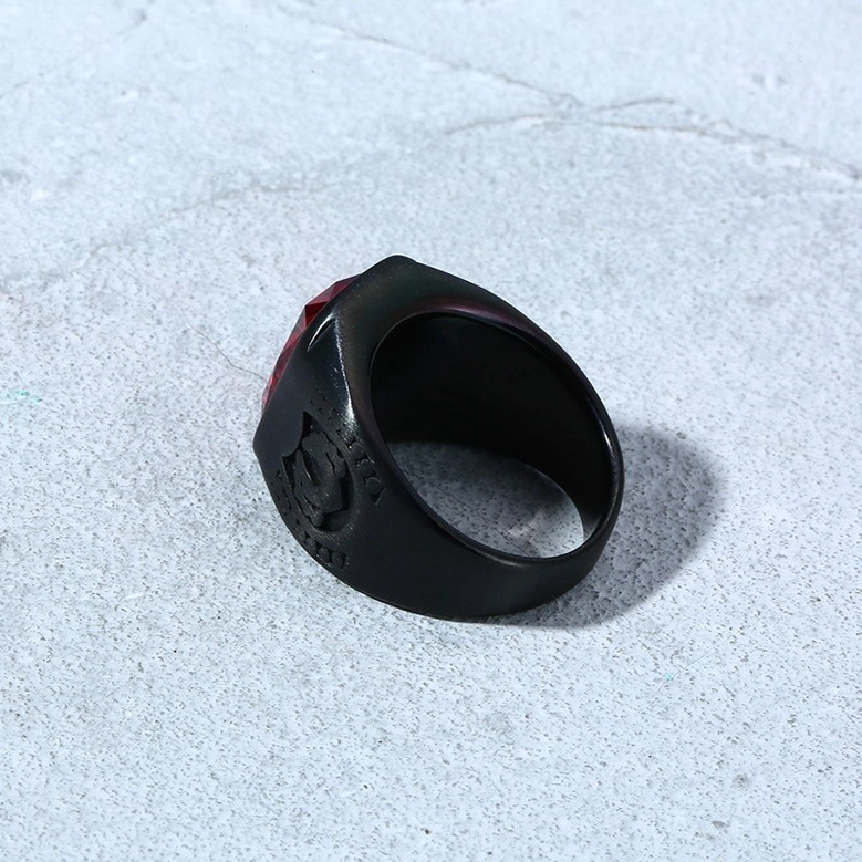 Gothic signet ring side view showing inner band and embossed details on gray concrete background