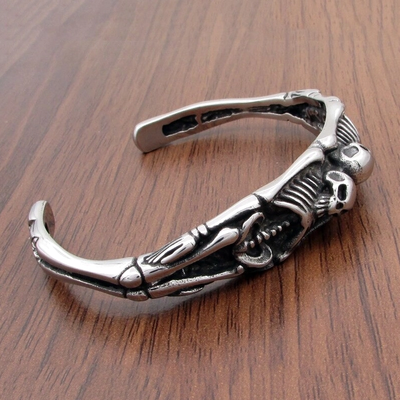 vintage silver skeleton bracelet on wooden surface showing metallic texture gothic style