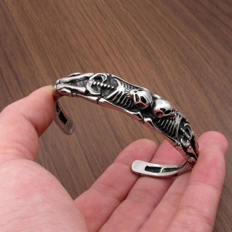 gothic skeleton bracelet on human hand wearing vintage silver stainless steel skull cuff