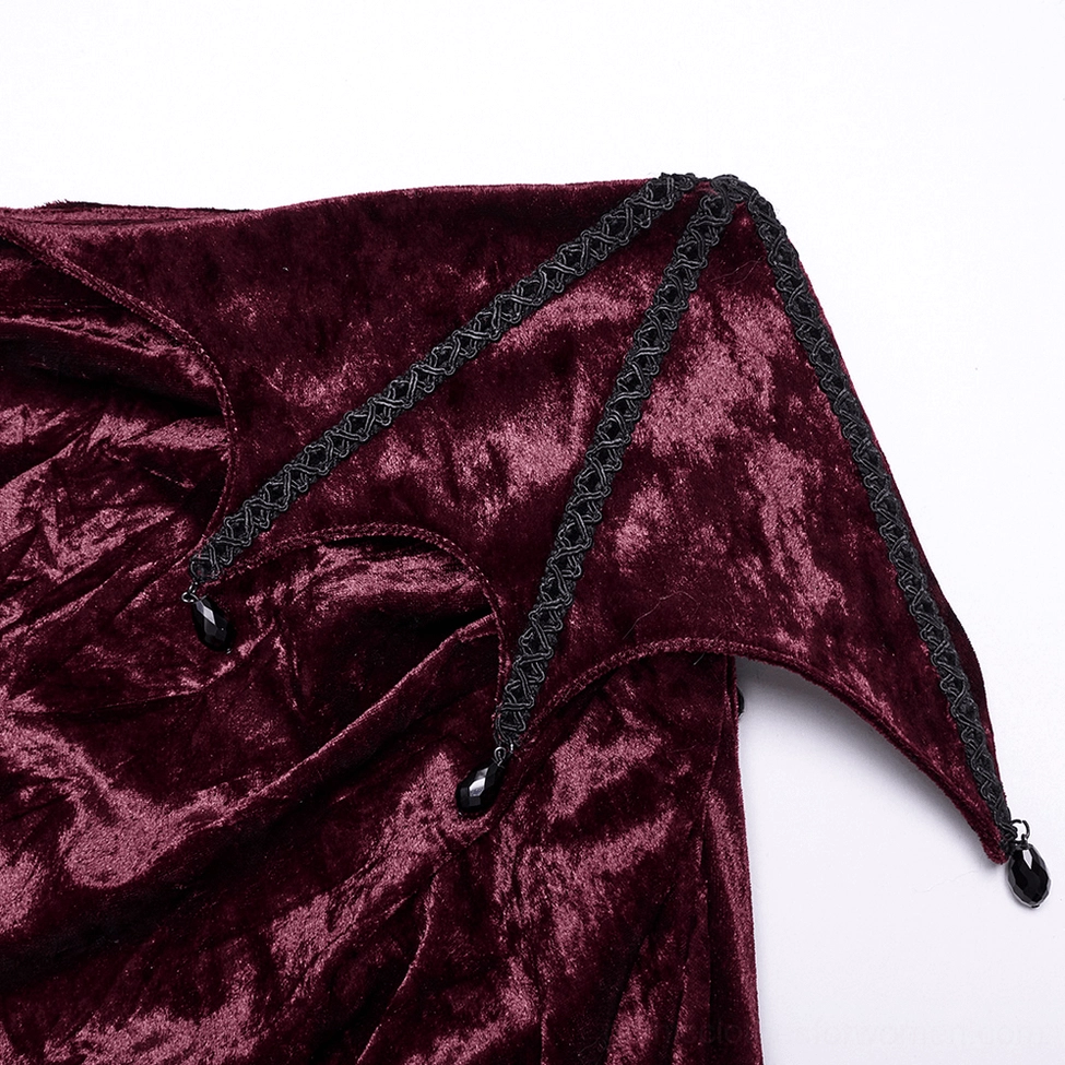 Close-up detail of gothic fishtail skirt showing black braided trim, decorative bead pendants, and crushed velvet texture