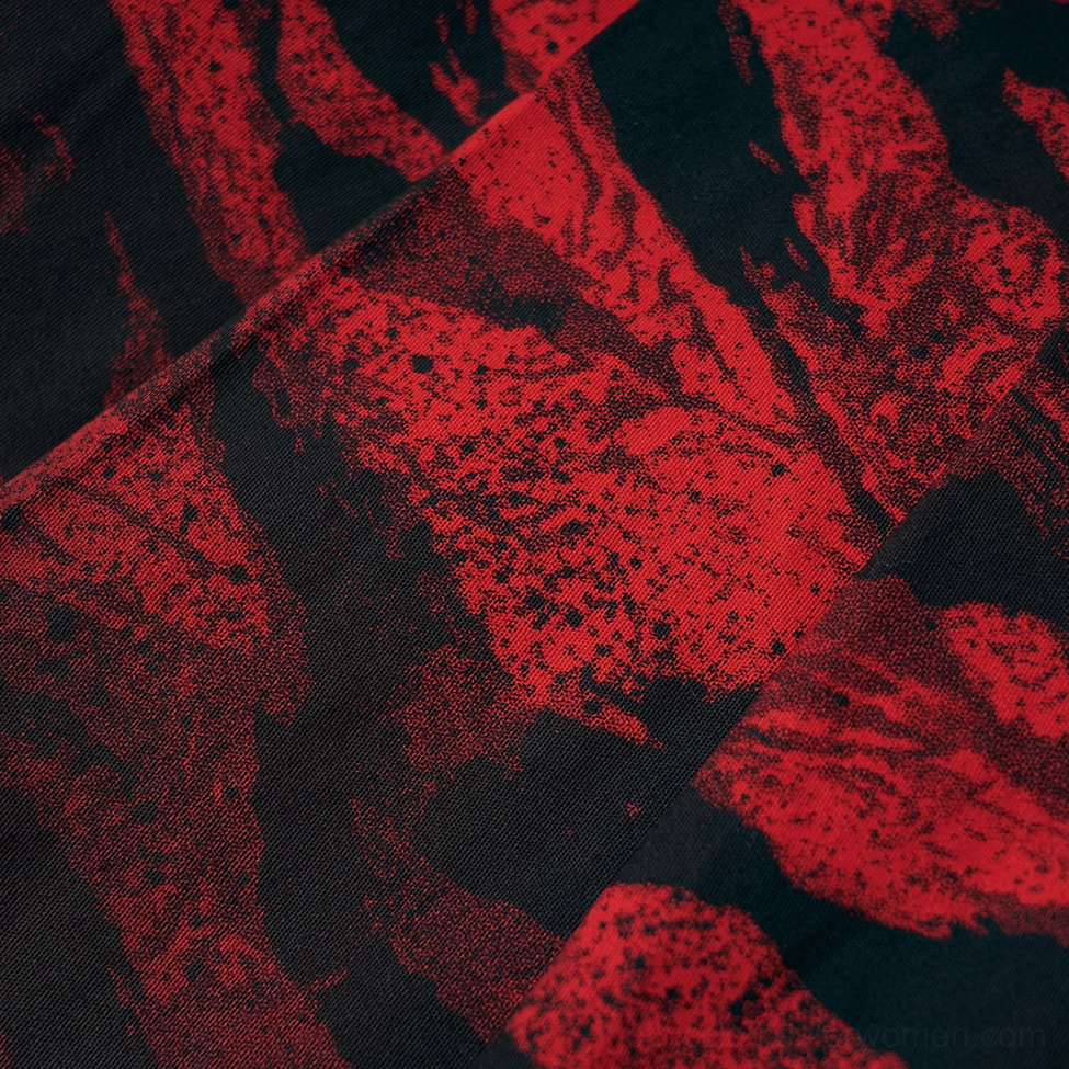 Macro texture shot of red-black abstract camo-inspired print and pleated fabric weave on gothic skirt