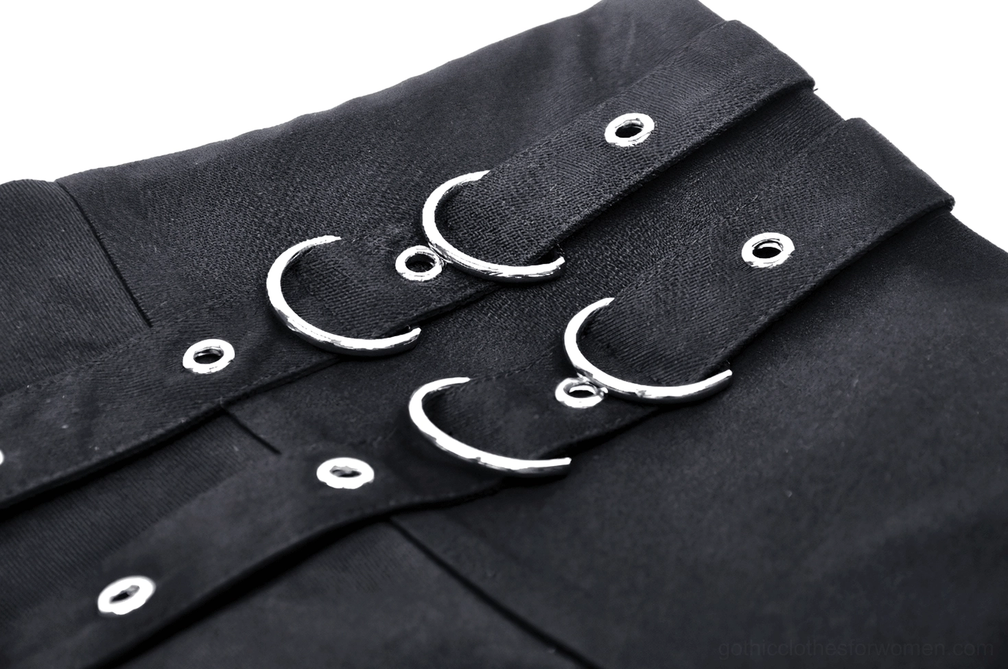 Close-up detail of black pleated gothic skirt metal O-ring hardware, rivets, and fabric construction
