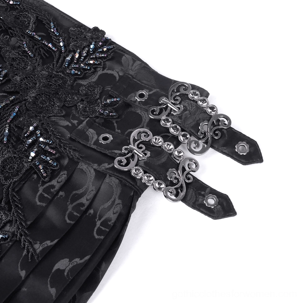 Macro close-up of gothic skirt hardware and lace embroidery featuring vintage metal buckles and intricate beaded lace on black fabric
