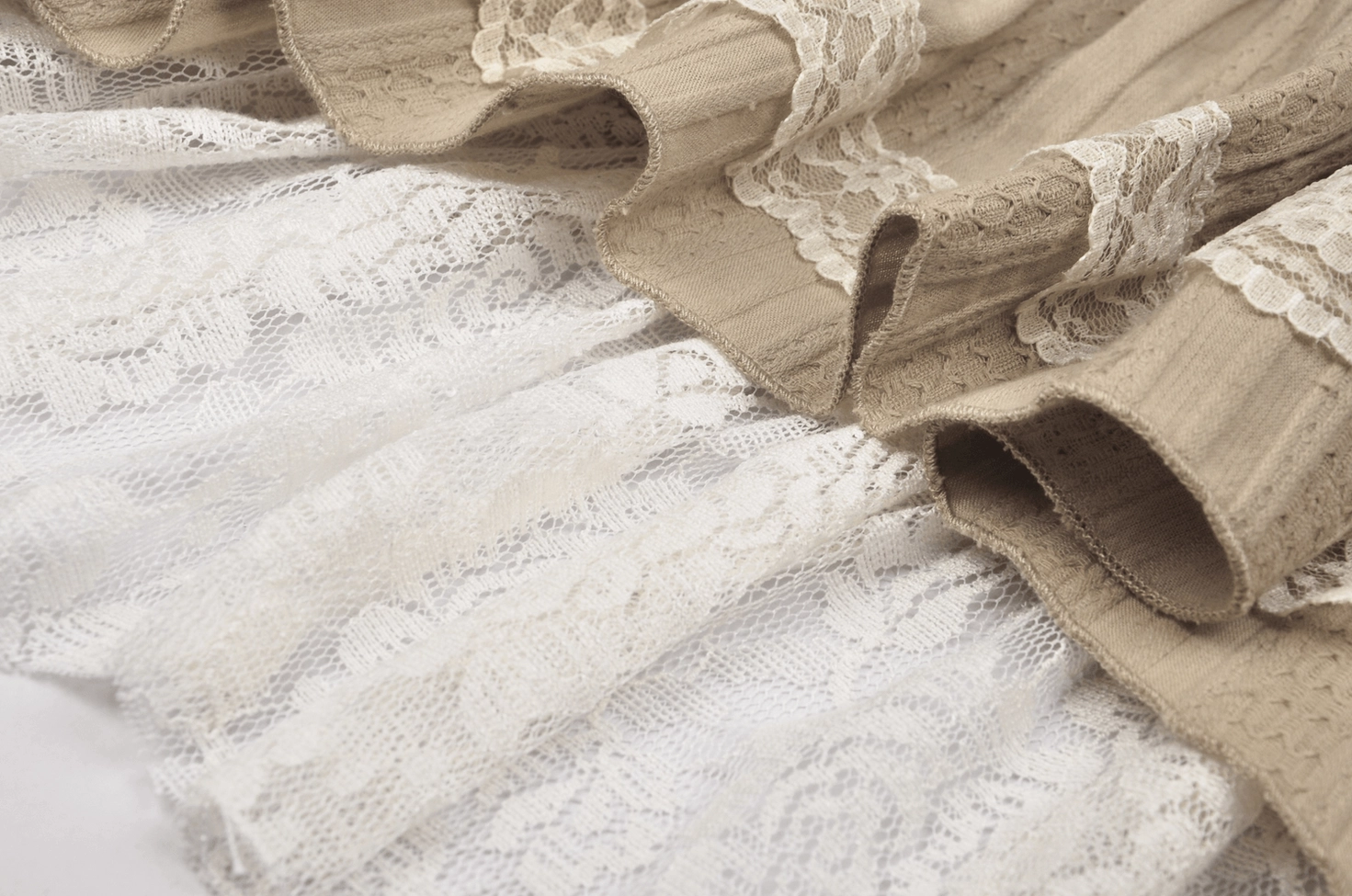 Close-up view of gothic skirt hem and floral white lace layer with ruffled fabric edges and intricate detailing