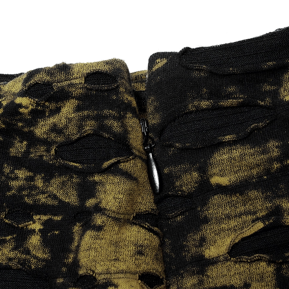 Macro detail shot of black lace trim hem on gothic distressed knit skirt with textured yellow-black ripped fabric base