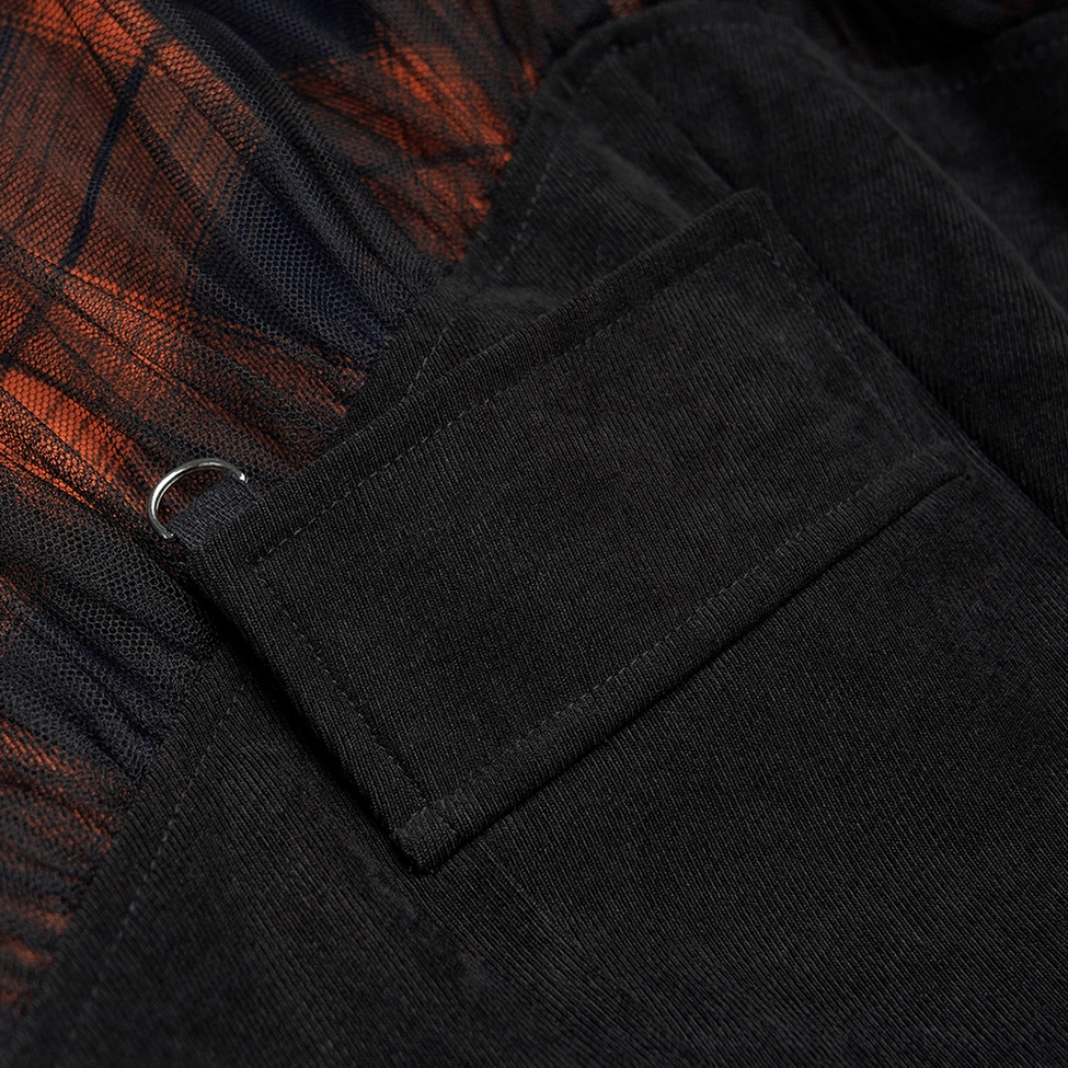 Close-up detail of black and orange plaid gothic mesh skirt side pocket featuring metal D-ring hardware and plaid fabric underlayer