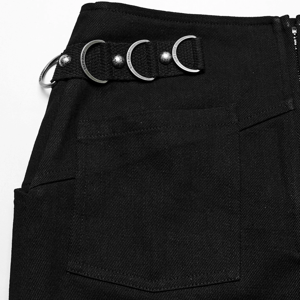 Close-up detail of black gothic skirt pocket hardware showing denim fabric, metal crescent rings and flap pocket