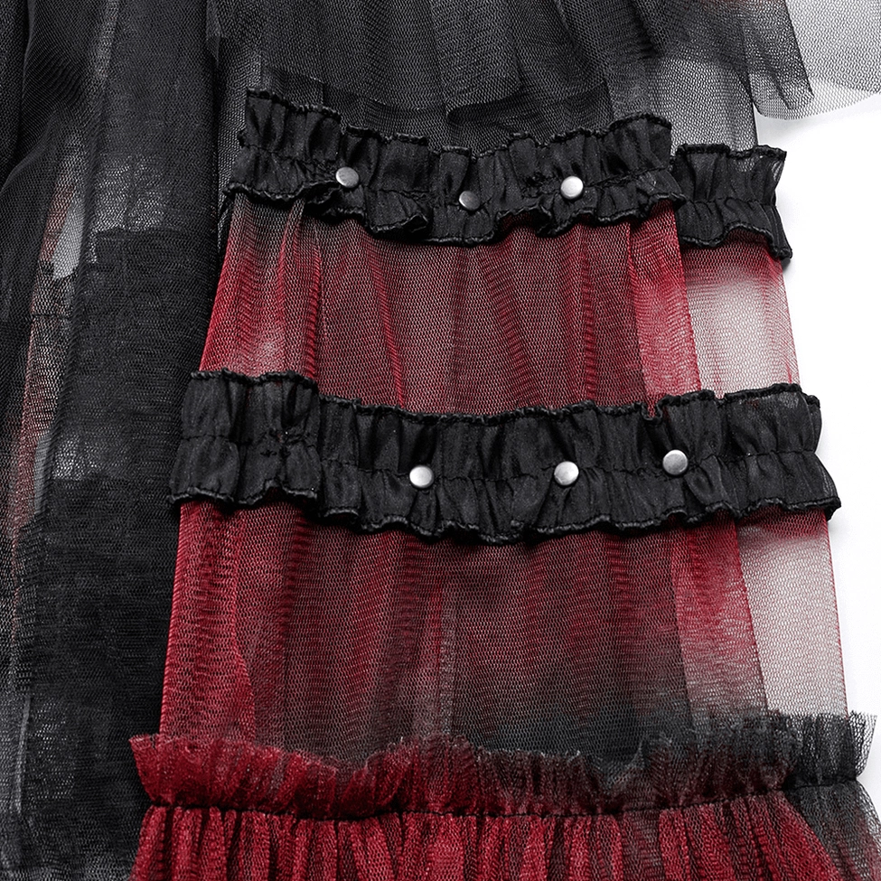 Gothic skirt ruffle trim close-up showing black ruffled band with metal studs and mesh gradient