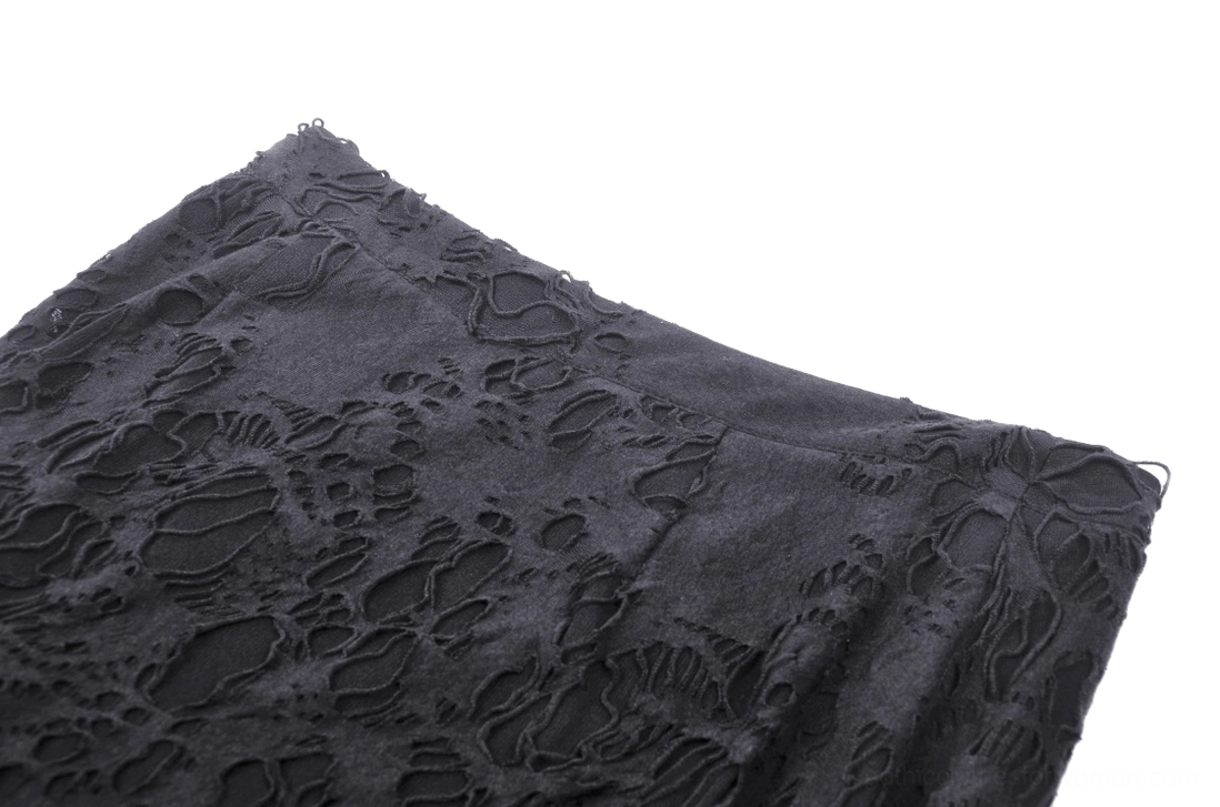 Close-up texture of black gothic skirt showing sheer floral lace pattern and matte black fabric finish