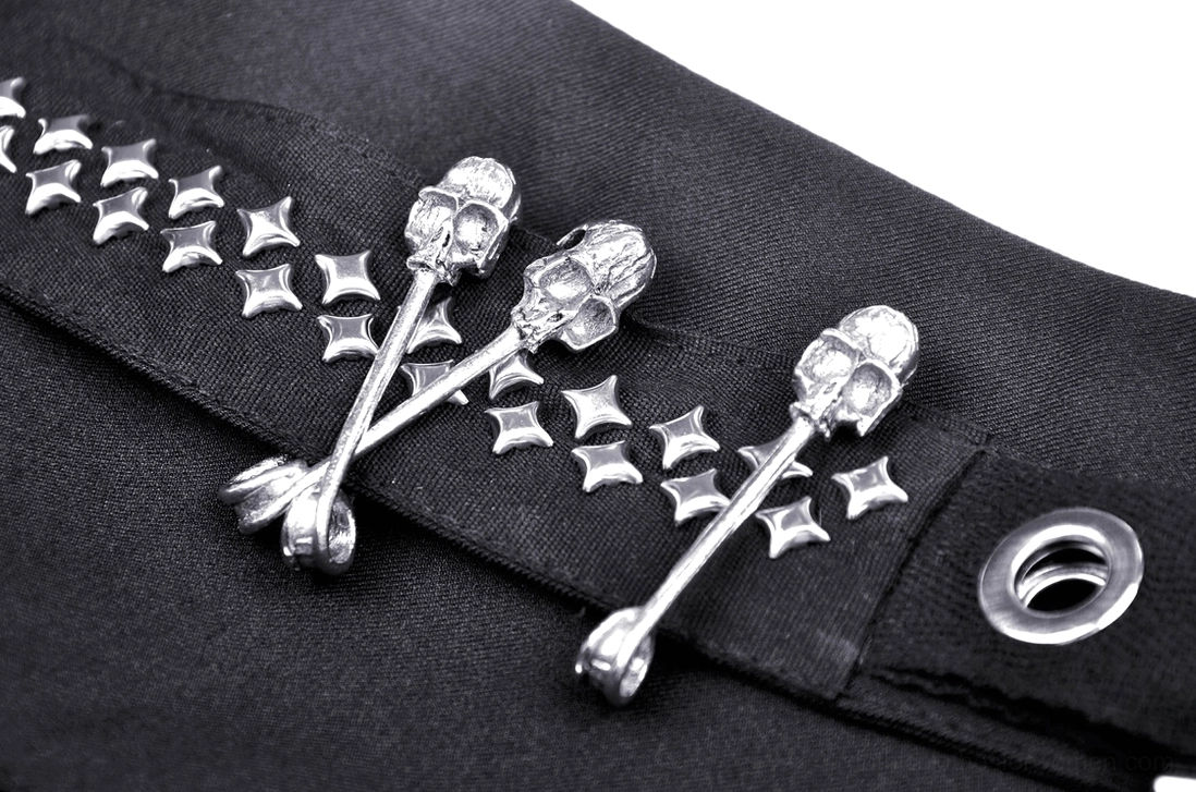 Gothic skirt waist decoration close-up showing skull crossbone charms, star studs, and metal grommets