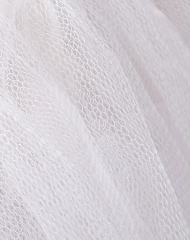 Close-up detail of white hexagonal mesh tulle fabric texture showing sheer layered construction