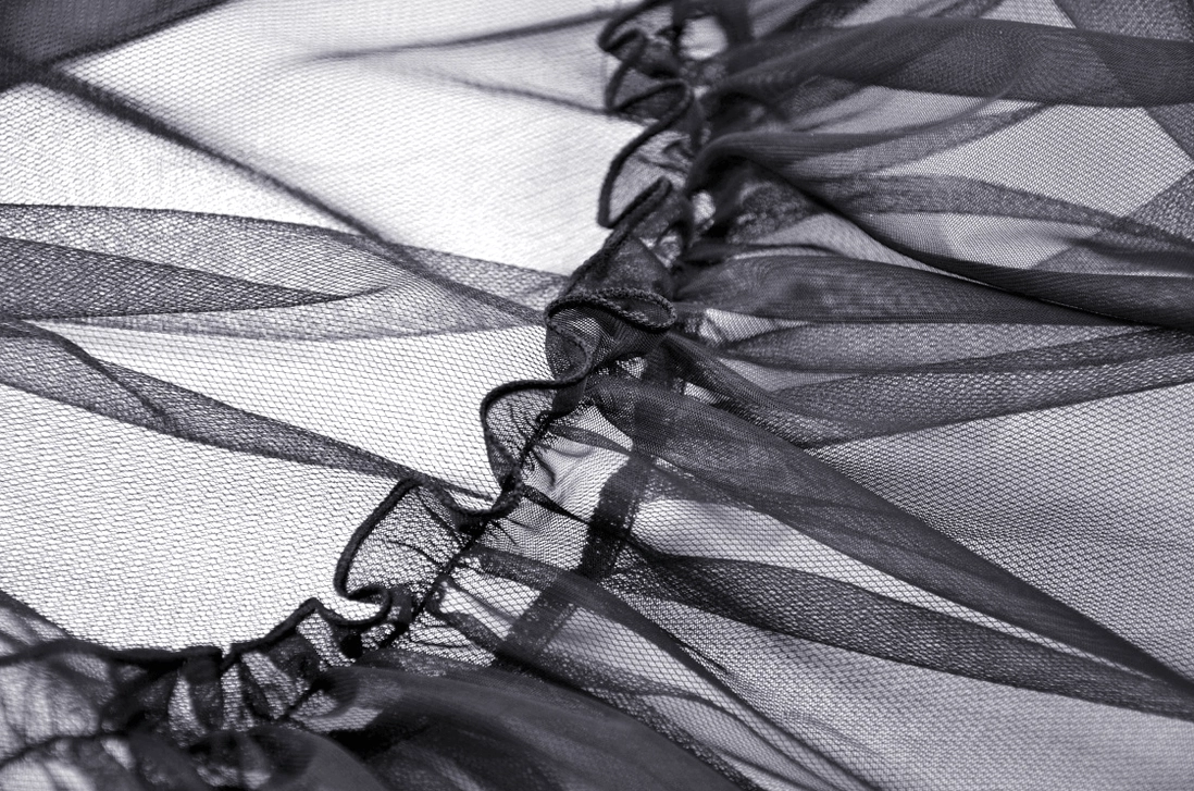 Detailed close-up of black sheer tulle mesh with ruffled edges showcasing fine texture of gothic skirt fabric