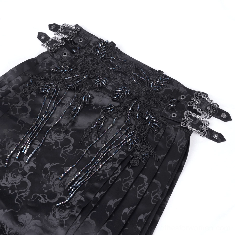 Close-up top-down view of gothic skirt waist detail showing beaded lace appliqué, tassel trims and vintage metal buckles on black jacquard fabric