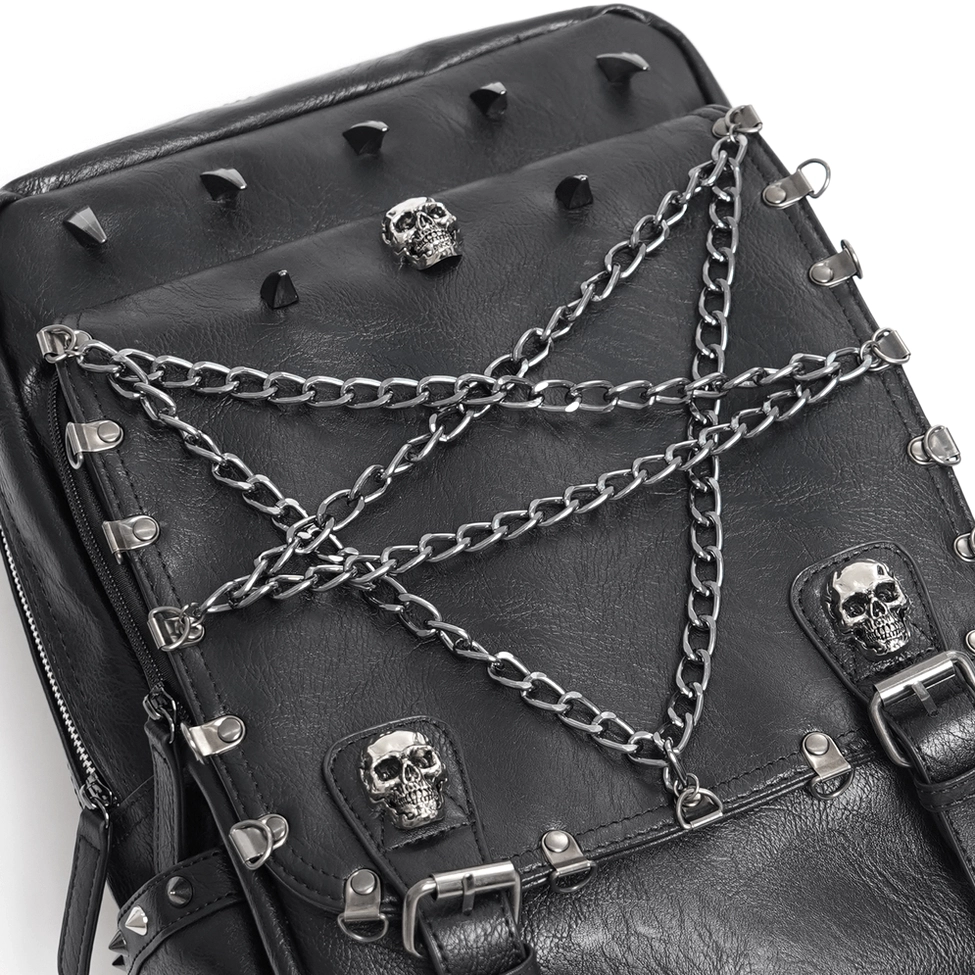 Close-up top-down detail of black gothic backpack front featuring pentagram chains, skull studs and spike decorations