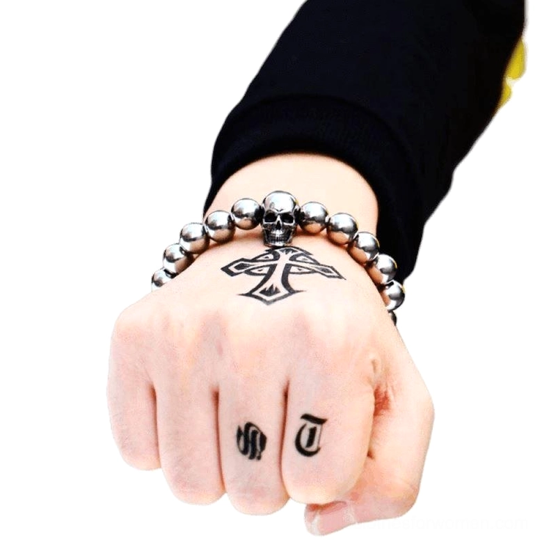 Gothic skull bead bracelet on tattooed male wrist - dark aesthetic jewelry styling on inked hand