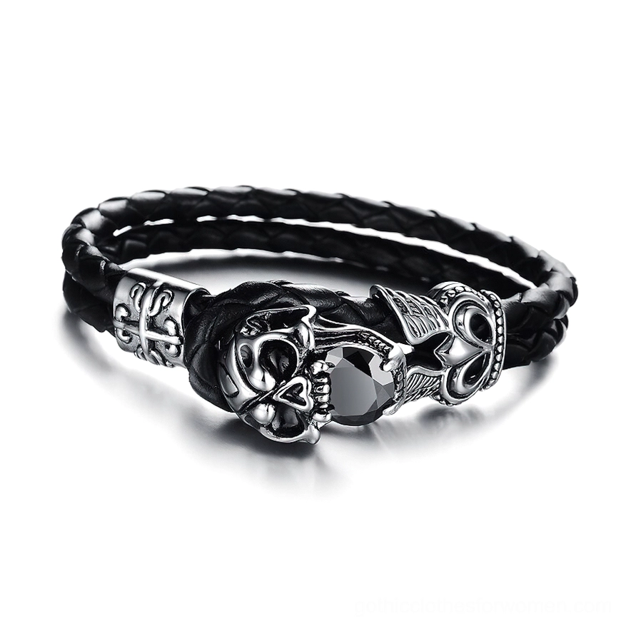 Skull charm genuine leather gothic bracelet with winged stainless steel design, three-quarter side view showing braided black leather and silver metal accents