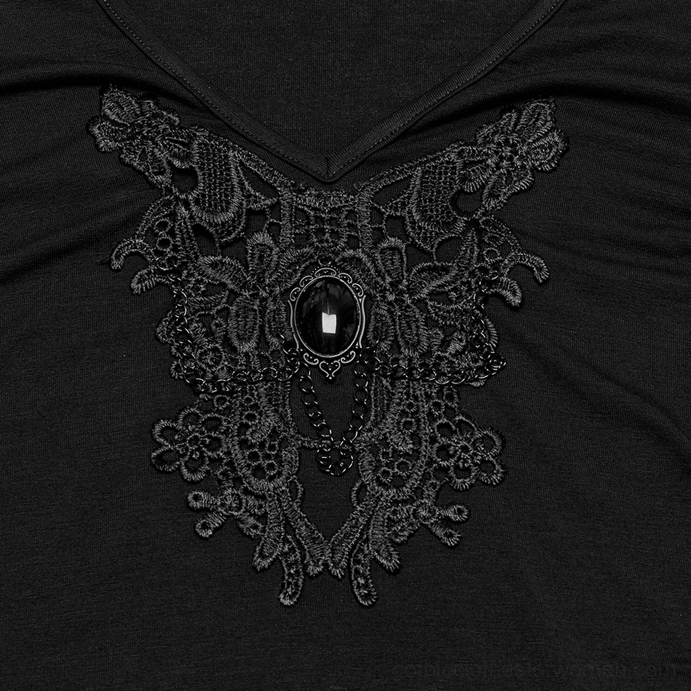Close-up of black lace chest applique with central gemstone chain accent and gothic skull design