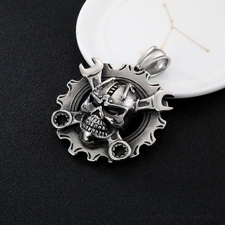 Vintage silver mechanical skull pendant on ceramic backdrop - detailed wrench and gear frame gothic jewelry