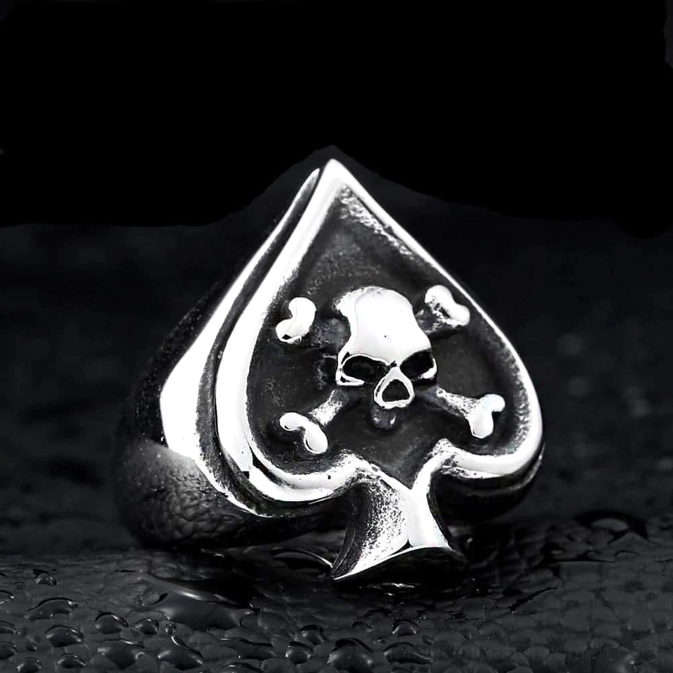 Darkened engraved spade skull cross ring recessed detail gothic aesthetic leather background