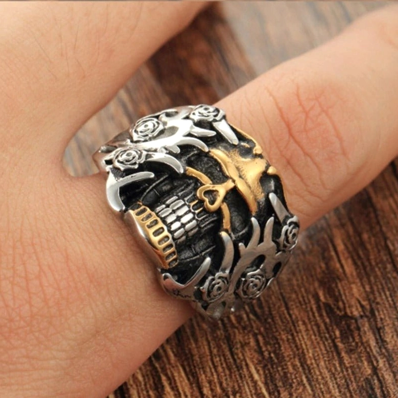 Retro gothic skull ring worn on finger showing how skeleton and rose carvings catch light with dual-tone finish