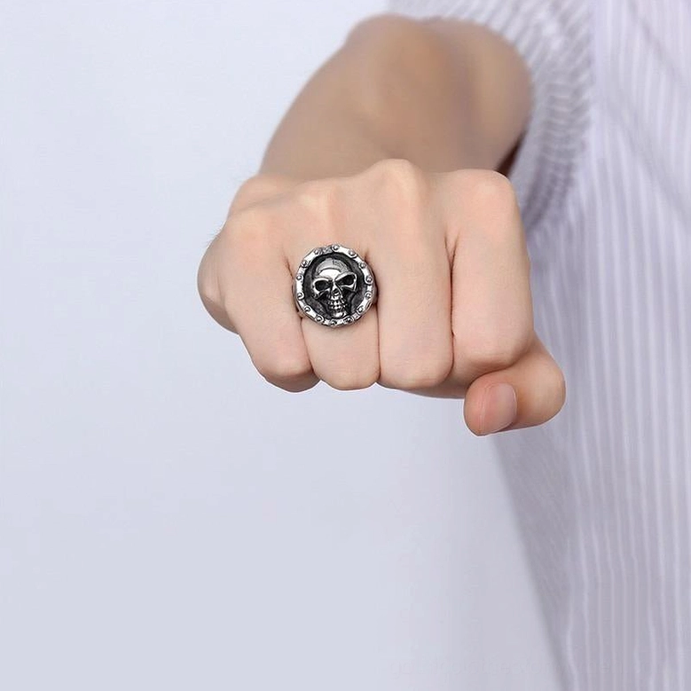 Vintage silver-tone skull ring worn on male hand showing gothic aesthetic in studio setting with alternative fashion styling