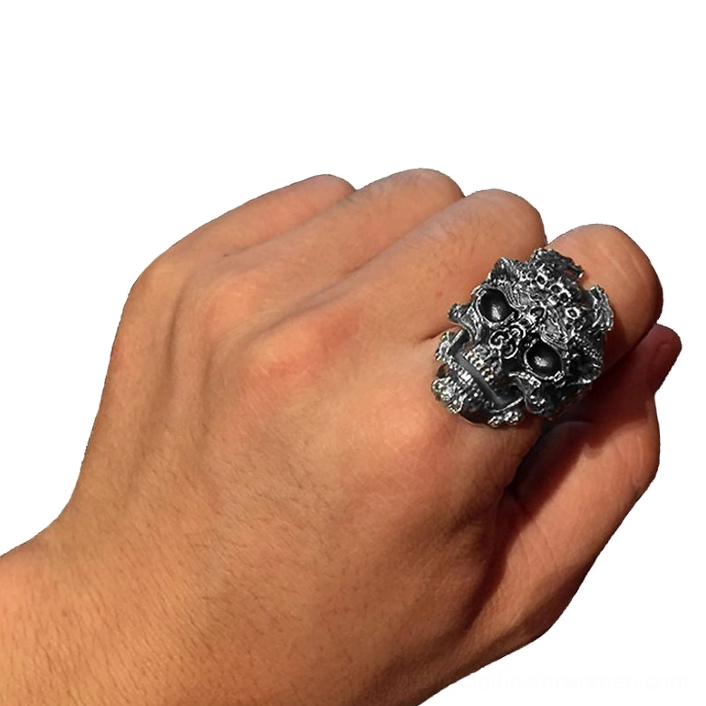 Men's hand wearing adjustable sterling silver gothic skull ring on middle finger, close-up shot demonstrating fit and presence