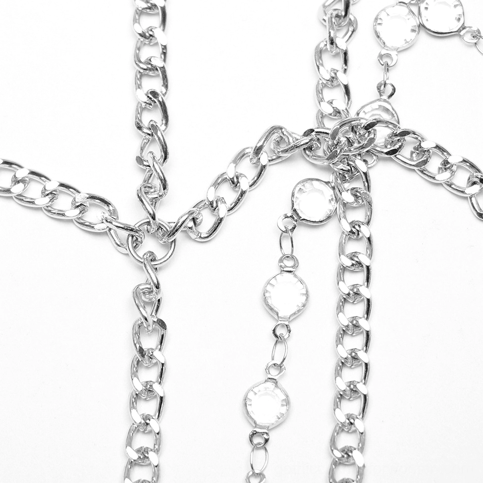 Close-up flat lay of thick silver curb chains linked with round crystals and chain components for gothic skull tiara