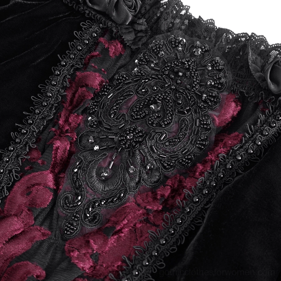 Close-up of burgundy damask floral embroidery and beaded lace edging on black velvet gothic sleeve