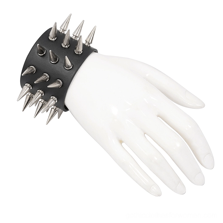 Black spike bracelet on white plastic hand mannequin from side angle, highlighting dense silver cone spike pattern and leather texture