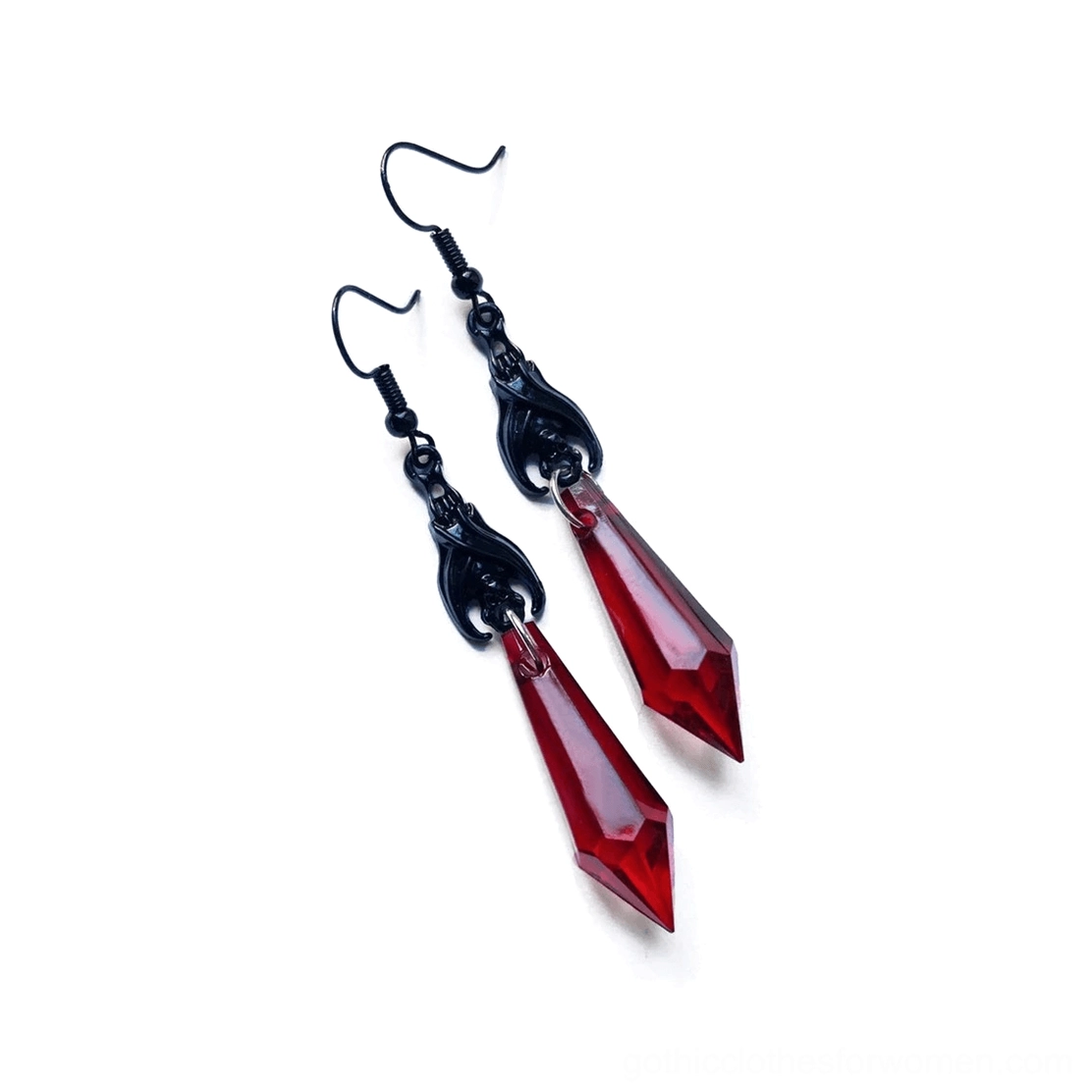 Red faceted spike drop earrings detail view, angled perspective showing geometric teardrop pendant construction and carved black hardware